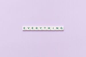 Scrabble tiles spelling 'Everything' on purple background.